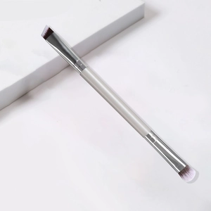 Dual-headed makeup brush with angled and round tips on a minimalist white background