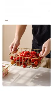 Detail showing gold metal fruit basket with side handles for easy lifting and carrying