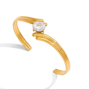 Gold plated stainless steel open bangle featuring a large oval cubic zirconia centerpiece