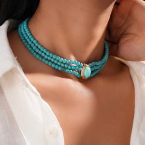 Detail view of bohemian turquoise multi-layer beaded necklace on a model neck