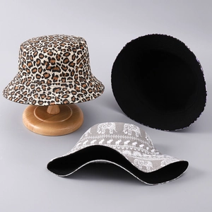Detail of grey elephant print and leopard patterns on stylish reversible bucket hats