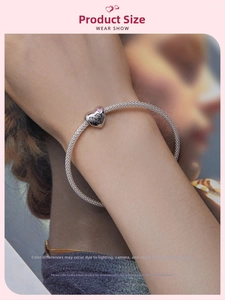 Silver mesh bracelet featuring a heart pendant with pink stones and floral engraving