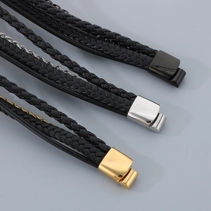 Detailed view of multilayer braided leather bracelets with gold, silver, and black magnetic clasps