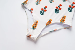Détail d'un maillot de bain fleuri montrant l'imprimé orange et les coutures de qualité