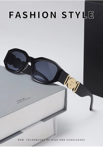 Detail of trendy small frame sunglasses featuring gold circular metal emblem on temples