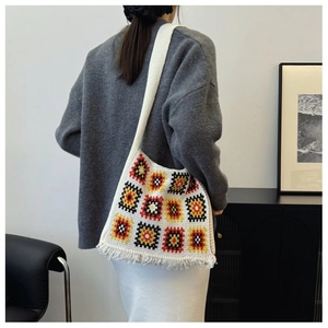 Detailed back view of a granny square crochet knit shoulder bag with fringe tassels
