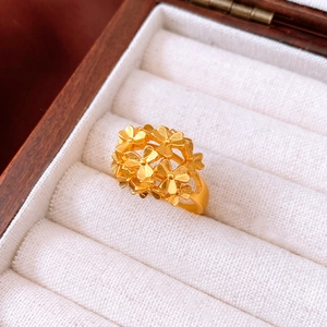 Macro detail of a 24k gold plated vintage flower ring inside a luxury wooden jewelry box