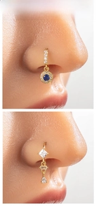 Detailed view of gold nose rings featuring blue sapphire and marquise zircon accents