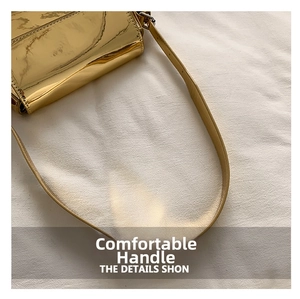 Close-up of metallic gold patent leather flap and matching flat shoulder strap detail