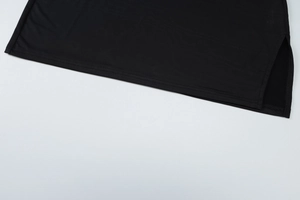 Close-up of double-stitched hem and side slit detail on black bodycon mini skirt