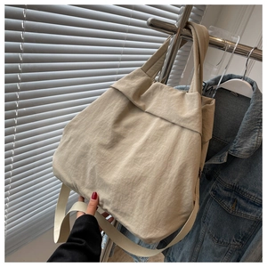 Detail of beige nylon tote bag featuring durable wide straps and wrinkled texture fabric
