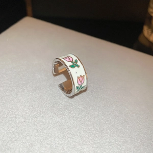 Detail of adjustable ring featuring white enamel finish and pink tulip floral patterns