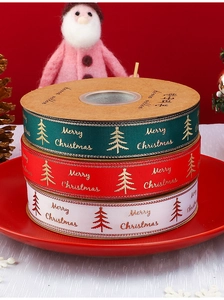Detail of red and green Merry Christmas ribbons with gold tree prints for gift wrapping