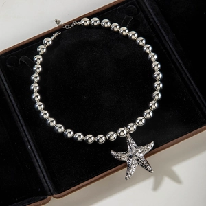 Close-up of silver starfish pendant necklace on premium black velvet jewelry box
