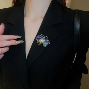 Detail of blue enamel flower brooch with pearl and crystal on black blazer lapel