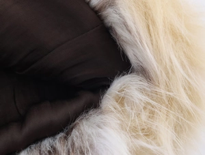 Detailed macro view of beige faux fur collar and dark brown lining fabric texture