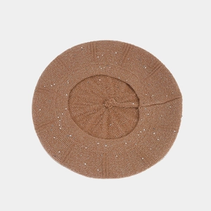 Detail of brown knit beret featuring shiny silver sequins and a top loop handle