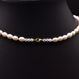 Elegant natural pearl and crystal necklace with 18k gold plating on black display