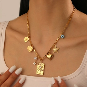 Vintage gold stainless steel necklace with sun, heart, star and eye charms on model