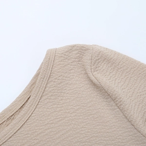 Macro detail of khaki textured fabric and precision stitching on round neck dress