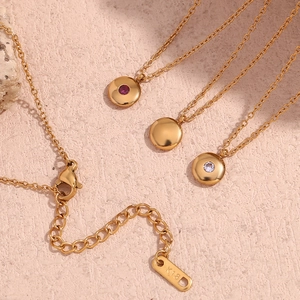 Detail of 18K gold plated necklaces with ruby and crystal monthly birthstone pendants