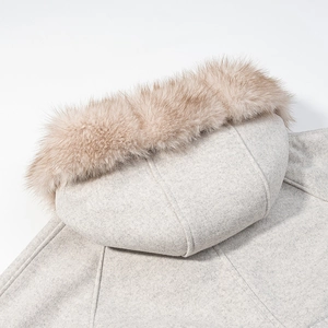 Détail du col en fourrure et de la capuche sur un manteau en laine gris pour femme
