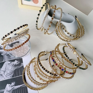 Detail of baroque alloy headbands featuring sparkling rhinestones and pearls on gold frames
