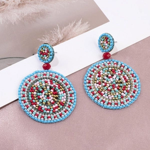 Close-up of handmade bohemian beaded hoop earrings with vibrant colorful geometric patterns