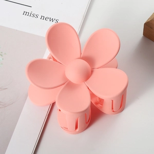 Detail van de roze matte bloem haarklem met zes bloembladen voor elegante kapsels