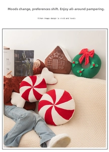 Cozy lifestyle scene with gingerbread house, wreath, and candy-themed Christmas pillows