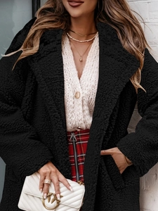 Detailed texture of women's black teddy fleece coat with soft faux fur finish