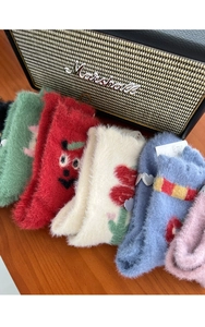 Close-up of fuzzy coral fleece socks with cute embroidery and heart metal buckles