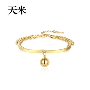 Close-up of gold stainless steel double chain bracelet with solid tube and round pendant