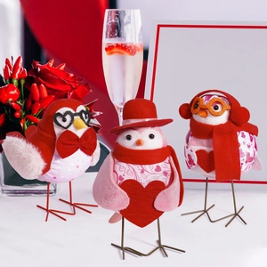 Detailed close-up of three Valentine themed plush birds with heart glasses and festive hats