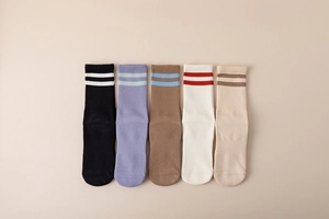 Flat lay of five pairs of cotton yoga socks in assorted colors with double stripe design