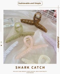 Close-up of assorted matte resin hair claws in pastel colors with golden metal springs