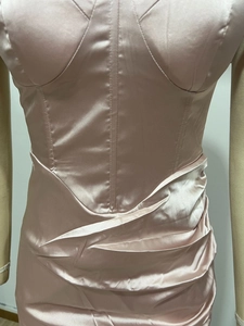 Dettaglio dell'abito in raso rosa con scollo a barca e dettagli drappeggiati laterali