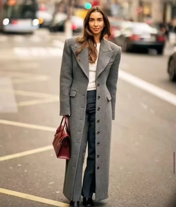 Detail view of the gray wool coat featuring peak lapels and premium textured fabric