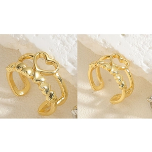 Macro shot of 14K gold plated C-shaped ear clip with layered hollow heart patterns