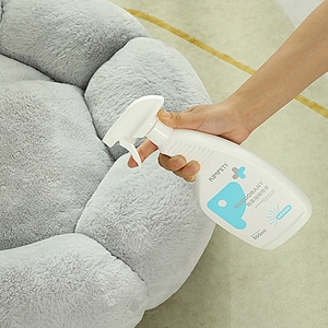 Kimpets 500ml pet odor eliminator spray being used on a gray fabric dog bed
