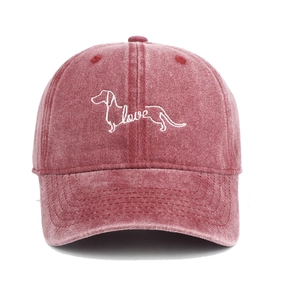 Detailed view of white dachshund embroidery and love text on red washed cotton baseball cap