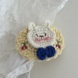 Close-up of handmade crochet bunny hair clip with cherry embroidery and lace detail