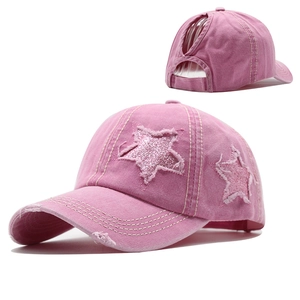 Détail de la casquette queue-de-cheval en coton rose avec étoiles à paillettes et usures