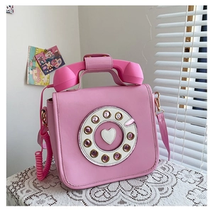 Detailed view of a pink retro telephone-shaped handbag with a vintage rotary dial design