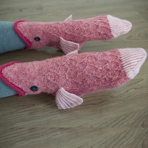 Macro detail of hand-knitted pink crocodile socks showing texture and 3D fin details