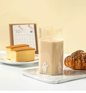 Detail of square glass cup with cute 3D bear pattern on a marble coaster