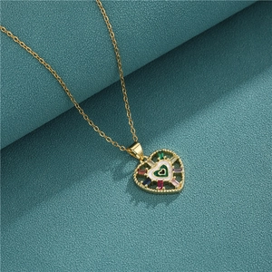 Golden heart pendant necklace with colorful zircons and white enamel on teal fabric