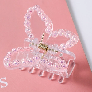 Close-up of butterfly hair claw with pink rhinestones and gold spring detail