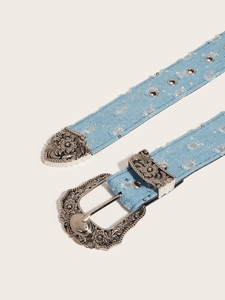 Detail of vintage blue denim belt featuring silver sequins and a carved metal western buckle