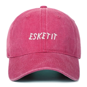 Detailed close-up of ESKETIT embroidery on a washed rose pink vintage baseball cap